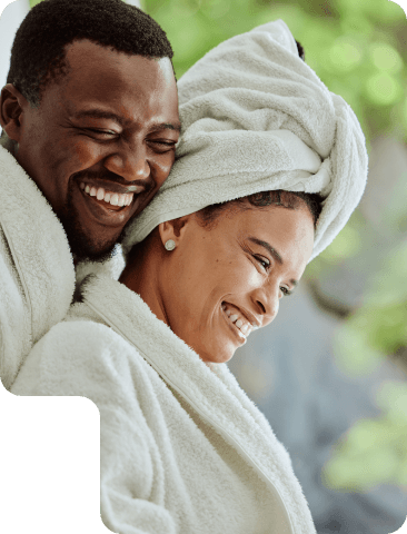 Couple in spa robes smiling after a wellness session